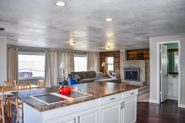Kitchen island with living room and fireplace beyond