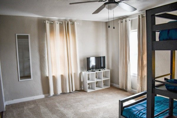 Bunk bedroom with a television and natural light